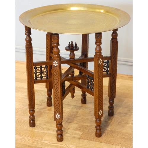 560 - An Indian brass top benares style table on folding hardwood base with mashrabiya panels and mother o... 