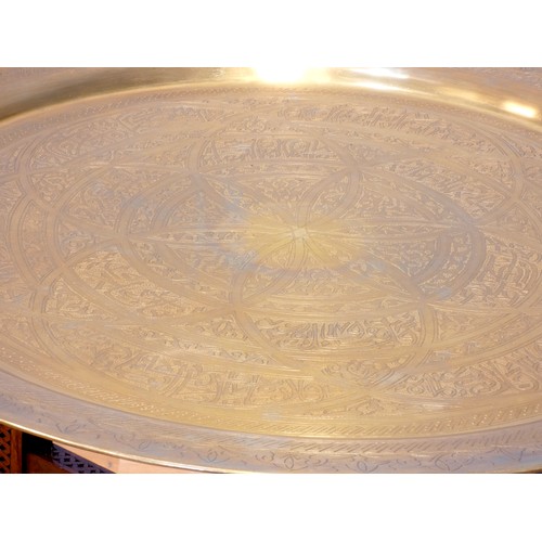 560 - An Indian brass top benares style table on folding hardwood base with mashrabiya panels and mother o... 