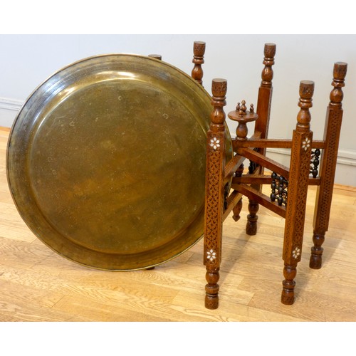 560 - An Indian brass top benares style table on folding hardwood base with mashrabiya panels and mother o... 