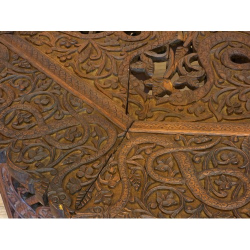 559 - An Anglo-Indian octagonal hardwood occasional table, on folding base, with intricate relief carved d... 