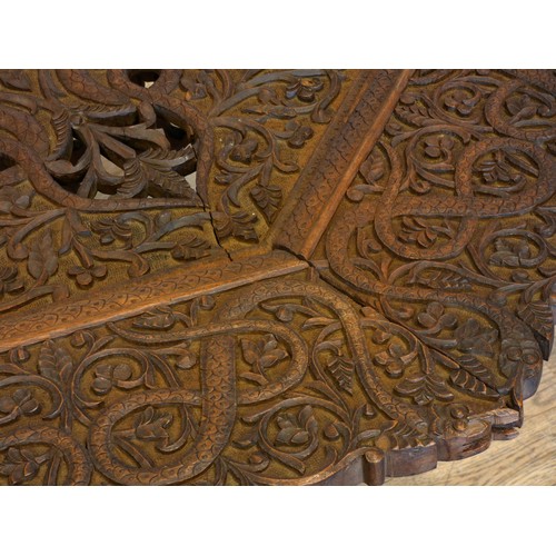 559 - An Anglo-Indian octagonal hardwood occasional table, on folding base, with intricate relief carved d... 