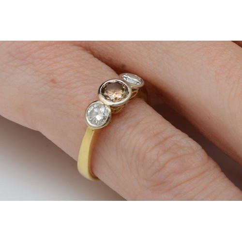 71 - An 18ct gold three stone brilliant cut diamond ring, collet set with a champagne stone, estimated to... 