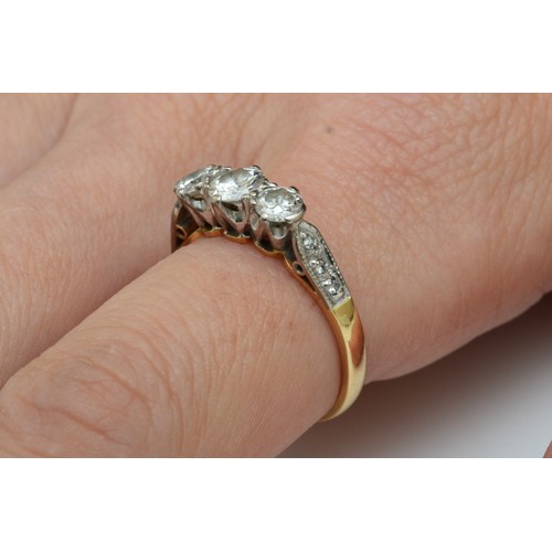 114 - An 18ct gold three stone diamond ring, London 1976, claw set with brilliant cut stones, approximatel... 