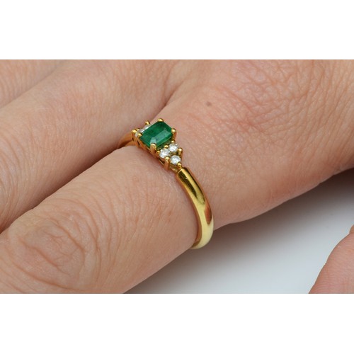 149 - An 18ct gold emerald and diamond ring, claw set with an emerald cut stone flanked by brilliant cut t... 