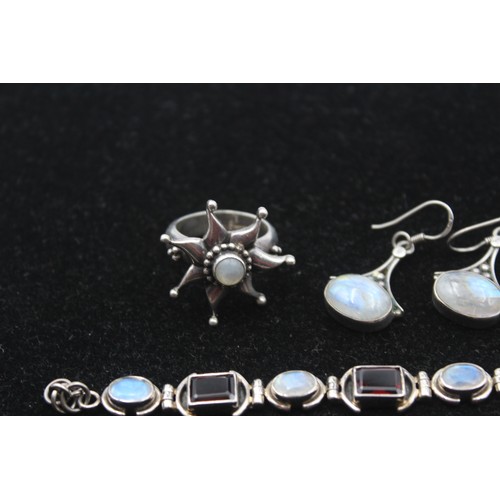 173 - A silver garnet and moonstone bracelet, a ring, cross pendant and pair of ear rings, 46gm