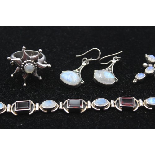 173 - A silver garnet and moonstone bracelet, a ring, cross pendant and pair of ear rings, 46gm