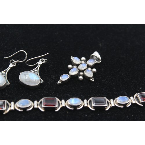 173 - A silver garnet and moonstone bracelet, a ring, cross pendant and pair of ear rings, 46gm