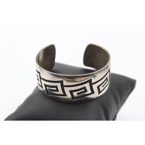 196 - A native American silver cuff bracelet, by Riley Polyquaptewa, with chased decoration, 25mm wide, 55... 