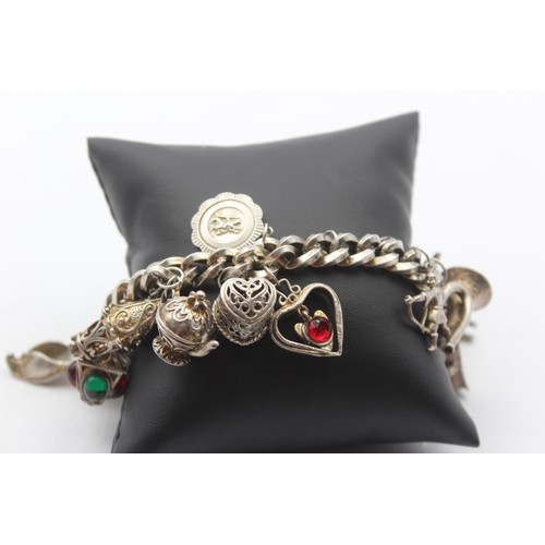 207 - A heavy silver charm bracelet, 111gm