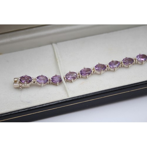 225 - A silver and amethyst line bracelet, 18cm and a silver gilt and peridot line bracelet, 19cm,