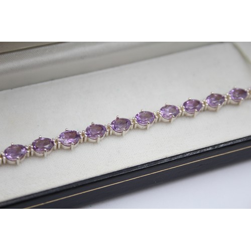 225 - A silver and amethyst line bracelet, 18cm and a silver gilt and peridot line bracelet, 19cm,