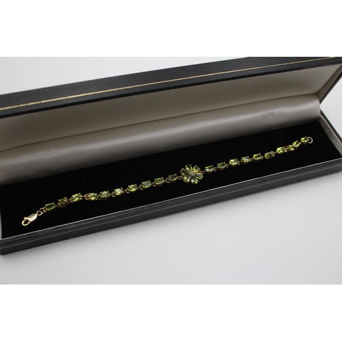 225 - A silver and amethyst line bracelet, 18cm and a silver gilt and peridot line bracelet, 19cm,