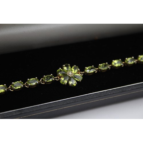 225 - A silver and amethyst line bracelet, 18cm and a silver gilt and peridot line bracelet, 19cm,