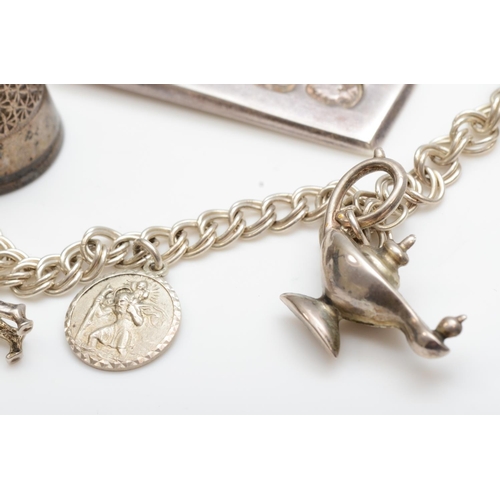 249 - A silver charm bracelet with boxer dog, an ingot pendant and two silver thimbles, 50gm