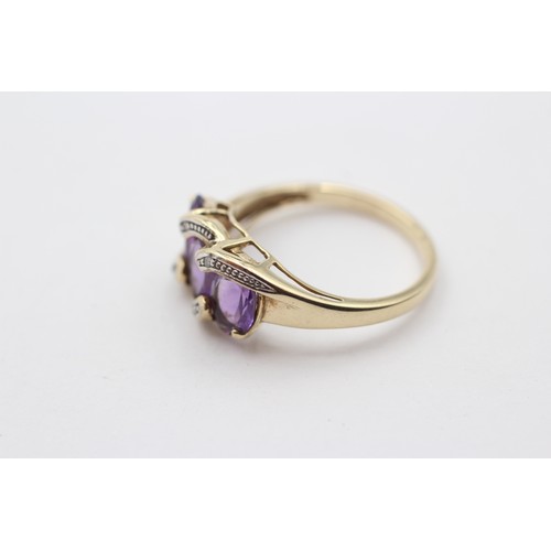 311 - A 9ct gold and three stone amethyst ring, diamond points between, N, 3gm