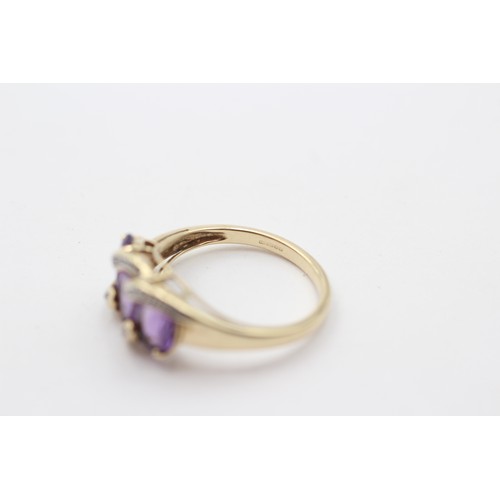 311 - A 9ct gold and three stone amethyst ring, diamond points between, N, 3gm