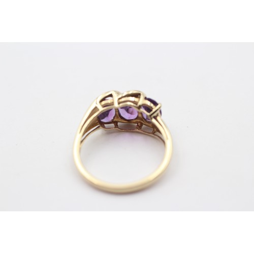 311 - A 9ct gold and three stone amethyst ring, diamond points between, N, 3gm