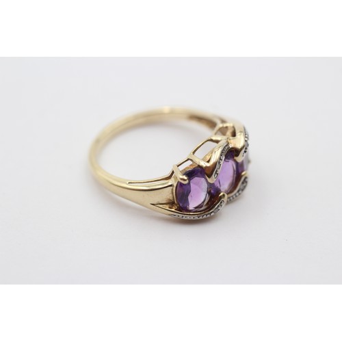 311 - A 9ct gold and three stone amethyst ring, diamond points between, N, 3gm