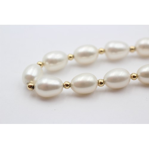 313 - A single row 10mm bead cultured pearl necklace with 14K gold beads between, 45cm