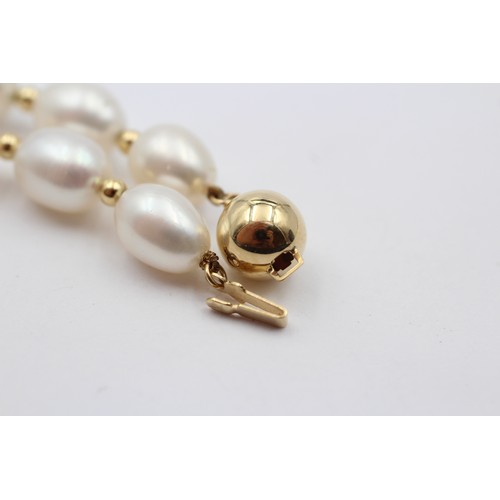 313 - A single row 10mm bead cultured pearl necklace with 14K gold beads between, 45cm