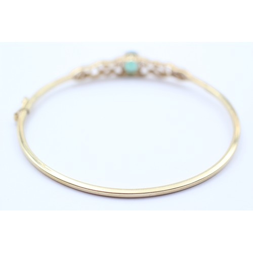 381 - A 9ct gold and green stone twist opening bangle, internal 60 x 52mm, 4.6gm