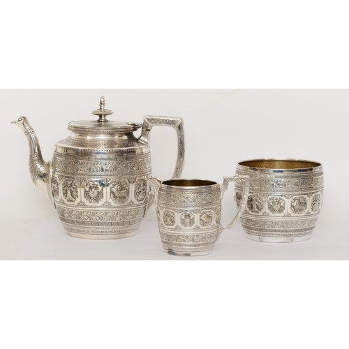 18 - A Victorian silver plated three piece tea set with repoussé images and chased decoration in the Indi... 