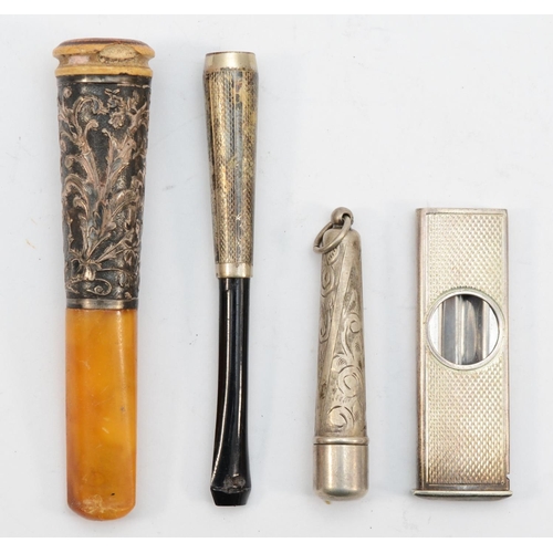 65 - An Elizabeth II silver cased cigar cutter, London 1980, together with silver capped cheroot holders.