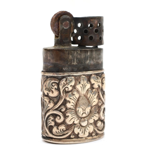 90 - A silver cased petrol lighter, unmarked, with embossed floral decoration, 6 x 3.5 x 2cm.