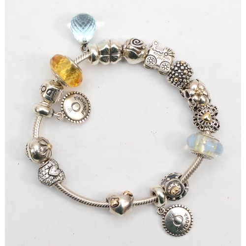 199 - Pandora, a boxed silver bracelet with fourteen charms, 69gm.