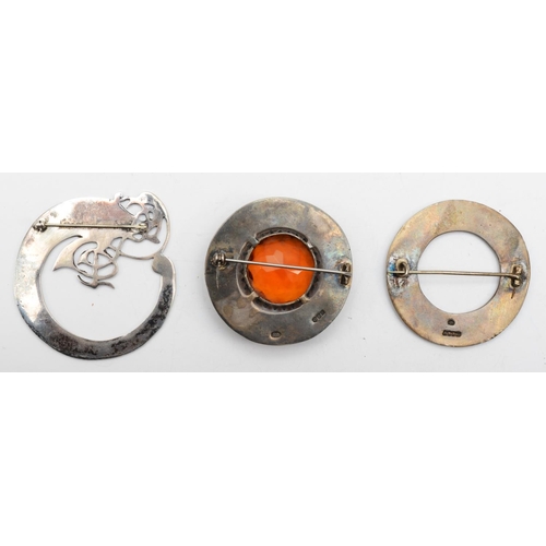 223 - Two Scottish silver brooches, one set with orange glass stone, Edinburgh 1962, together with a peaco... 