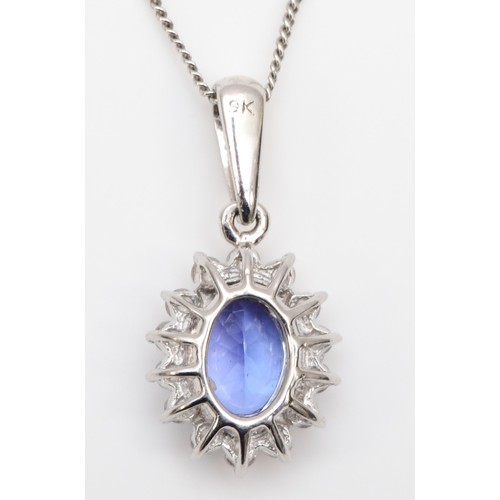 299 - A 9ct white gold tanzanite and CZ cluster pendant, 17mm overall, chain, 1.6gm