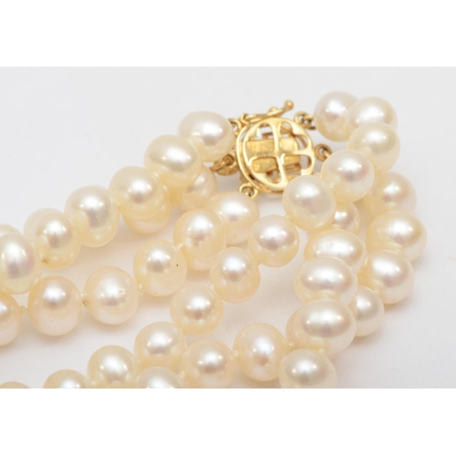 328 - A 14ct gold three strand cultured pearl necklace, 46cm, 6mm pearls, 75.6gm.