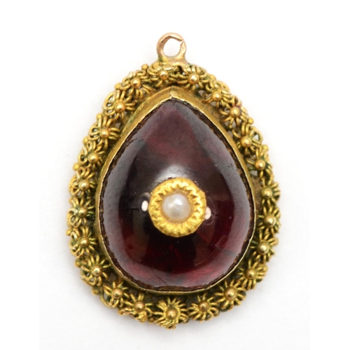 374 - A gold mounted foil backed garnet centered with a seed pearl, 11 x 22mm, 3.3gm.