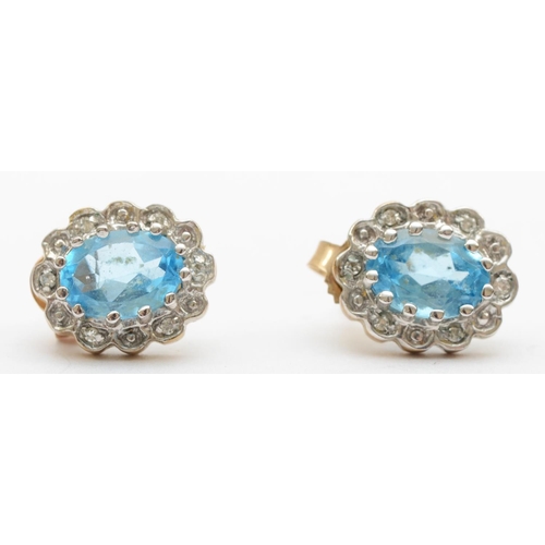 378 - A 375 gold pair of topaz and illusion set diamond cluster earstuds, 1 cm, 1.8gm.