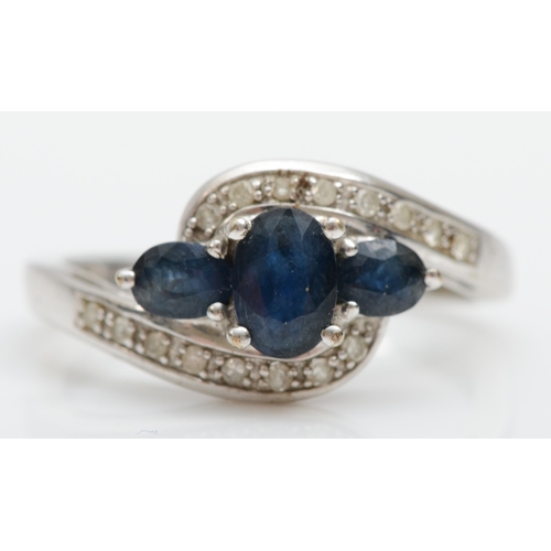 513 - A 9ct white gold three stone sapphire ring, diamond set shoulders, K, 2.3gm