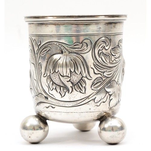 11 - A 19th century German silver beaker, makers mark KW with 19 in a circle, with embossed floral decora... 