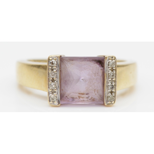 103 - A 9ct gold princess cut amethyst dress ring, the amethyst flanked by diamonds, P, 3.8gm.