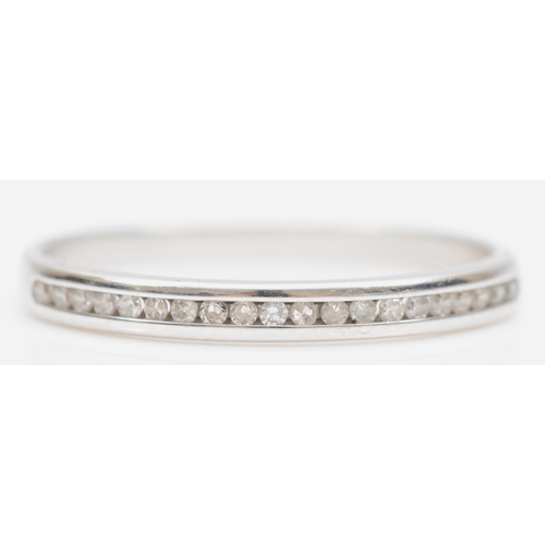 105 - A 9ct white gold channel set brilliant cut diamond half eternity ring, P, 1.3gm.