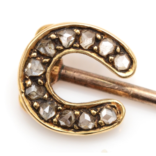 120 - A Victorian unmarked gold horse shoe stick pin, set with mine cut diamonds, 5cm, 1.2gm.