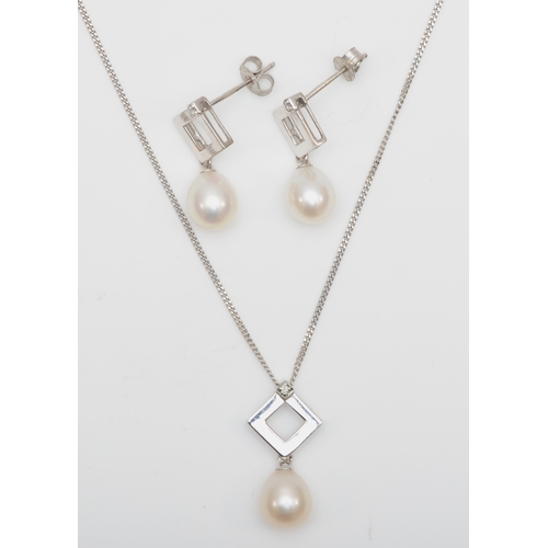 124 - A 9ct white gold cultured pearl and diamond pendant on chain, 19mm, with a matching pair of drop ear... 