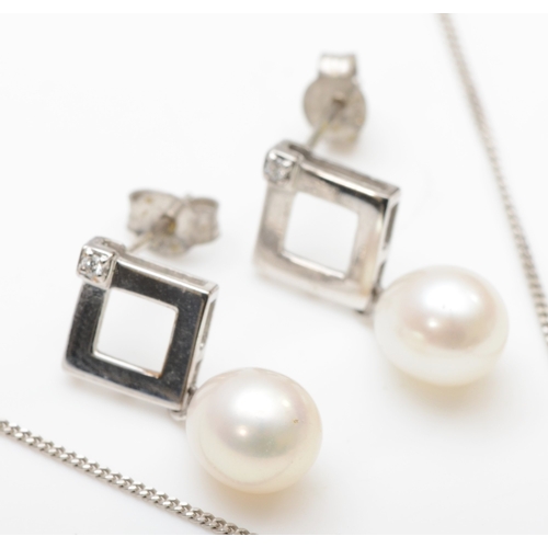 124 - A 9ct white gold cultured pearl and diamond pendant on chain, 19mm, with a matching pair of drop ear... 