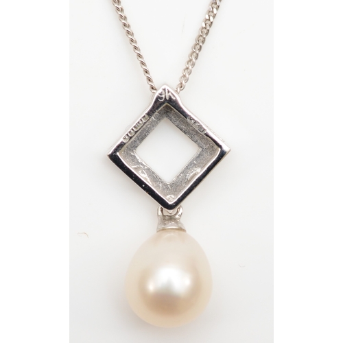 124 - A 9ct white gold cultured pearl and diamond pendant on chain, 19mm, with a matching pair of drop ear... 