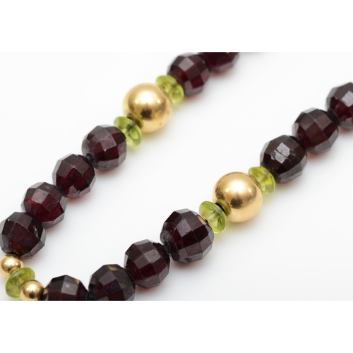 140 - A 14k gold clasped garnet and peridot beaded necklace, 7 - 5mm beads, 39.5gm.