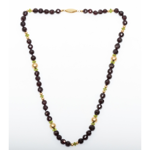 140 - A 14k gold clasped garnet and peridot beaded necklace, 7 - 5mm beads, 39.5gm.