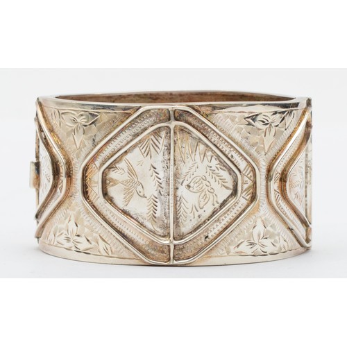 164 - A vintage silver cuff bangle, Birmingham 1994, with chased foliate, bird and insect decoration, 59mm... 