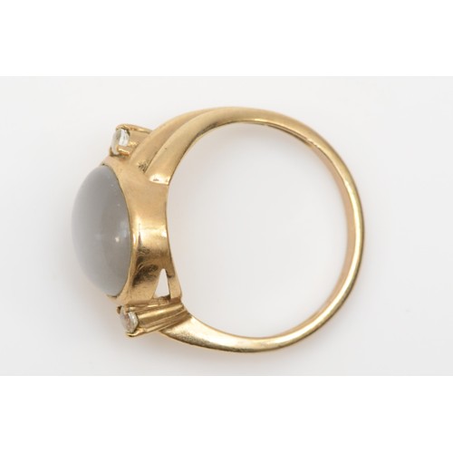 175 - A 9ct gold moonstone dress ring, 11 x 9mm, flanked by two white stones, O, 3.6gm.