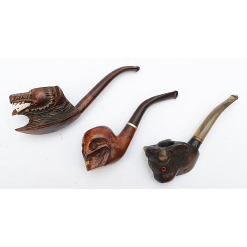 238 - Three 20th century carved Black Forest style pipes, the bowls carved in the form of a skull, wolves ... 