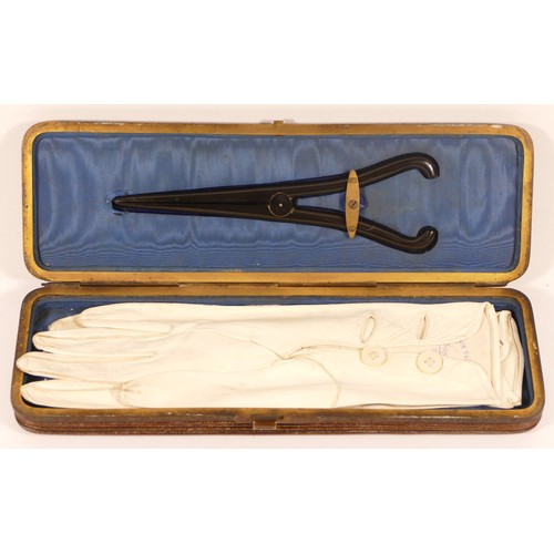 244 - A late 19th century cased pair of gloves with a pair of glove stretchers, 27cm wide.