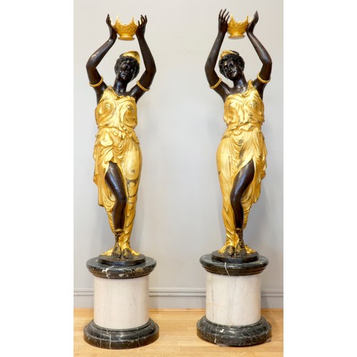 251 - An impressive pair of cast bronze female Blackamoor torcheres, the ladies in gilt dresses holding bo... 