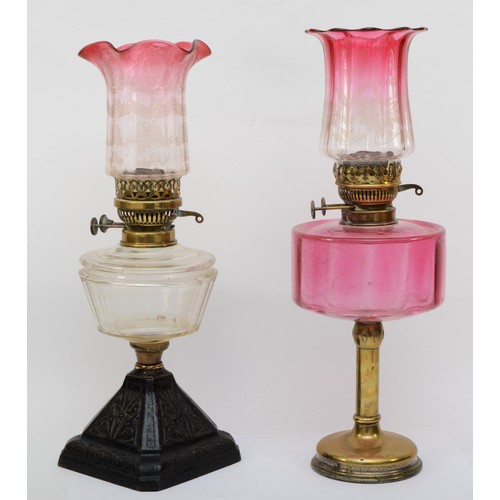 256 - A 19th/early 20th century brass and glass oil lamp, with clear and cranberry glass shade etched with... 